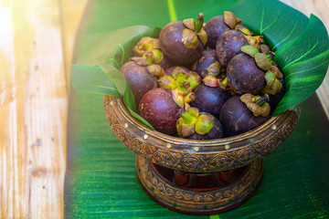 Mangosteen on the Asian Thai vintage phan or tray on the wood table. They ready to serve for seminar coffee break time.