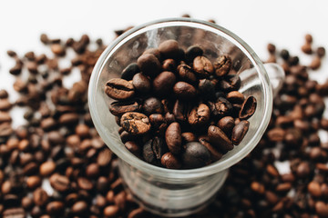 Close-up view of roasted coffee beans and glass cup 