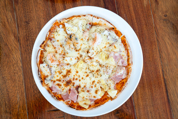 Simple and basic normalI solated full circle Pizza in White dish on wood table with clipping paths