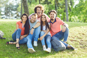 Fototapeta premium A group of friends laughing hugging sitting in a park