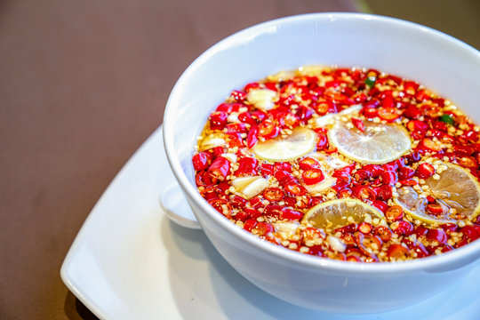 Close up Thai Sauce traditional style. Chilli fish sauce with lemon lime and garlic in white bowl.