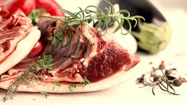 Saddle of mutton - raw red meat , lamb - with vegetables. herbs and spices on wooden table. Slow pan