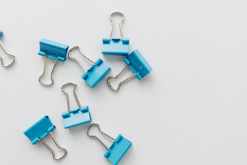 Pile of blue paper clips on blue background