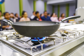The Gas fire from the stove with the pan on it, in the training - study cooking classroom.