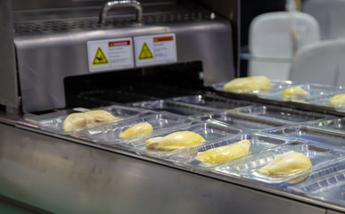 Package of durian fruit on linear tray food heat sealing and packing machine. Food industry