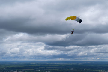 Skydiving. A parachute is in the sky.