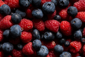close up view of delicious and fresh ripe mixed raspberries and blueberries