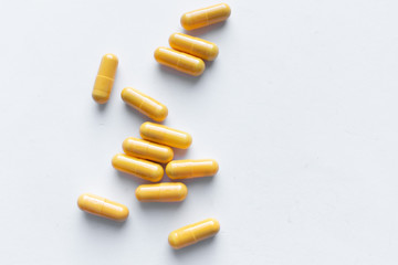 Scatterded yellow pills on white background