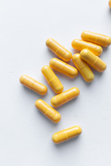 Scatterded yellow pills on white background