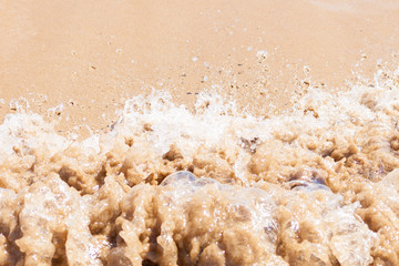 Close up of dirty wave of sea or ocean on sandy beach. Background.