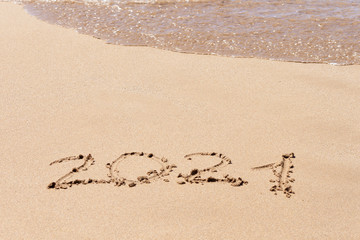 Happy new year 2021 text on the beach. Planning vacation.