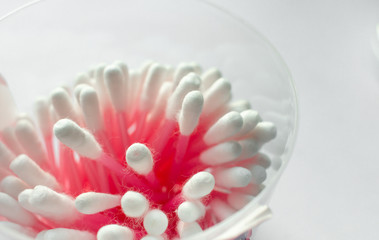 Red cotton swabs on white background