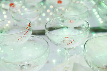 empty champagne glasses on the table with LED illumination.  bar table after the party with transparent glass glasses and the remnants of champagne. concept of a fun party, celebration, wedding, prom