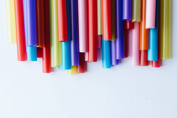 Pile of colorful cocktail straws over white background