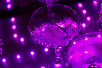 empty champagne glasses on the table with LED illumination.  bar table after the party with transparent glass glasses and the remnants of champagne. concept of a fun party, celebration, wedding, prom