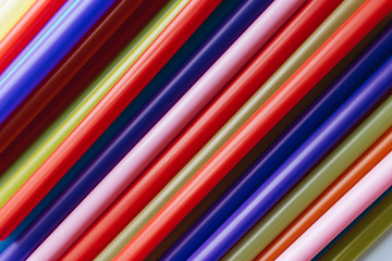 Pile of colorful cocktail straws over white background