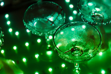 empty champagne glasses on the table with LED illumination.  bar table after the party with transparent glass glasses and the remnants of champagne. concept of a fun party, celebration, wedding, prom