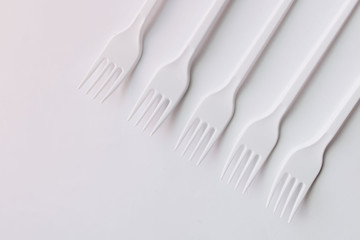 White plastic forks flat lay on white background