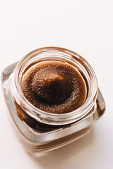 Chocolate cream in small jar on white background