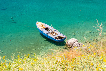 boat on crystal clear water of ionian sea in Porto Palermo in Albania