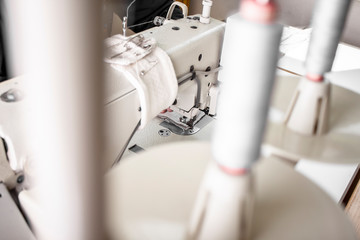 professionelle Näherin näht mit Inustrienähmaschine einen Kissenbezug aus Stoff