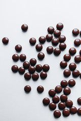 Pile of scattered chocolate dragee on white background