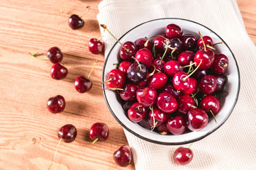 Fresh cherry in bowl on rustic background