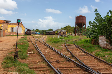 View of an Abandonned rail road station with an old train during a sunny and cloudy day. Taken in Trinidad, Cuba.