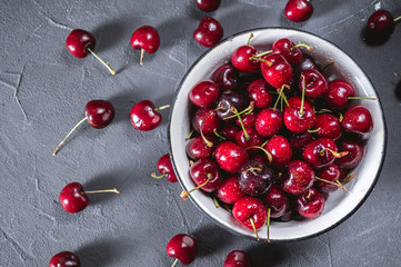 Fresh cherry in bowl on rustic background