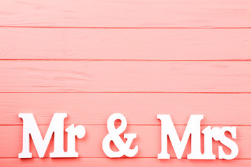 White letters Mr and Mrs on pink wooden table