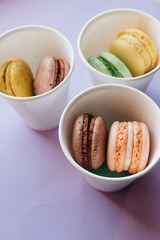 Composition of delicious macaroons on purple background