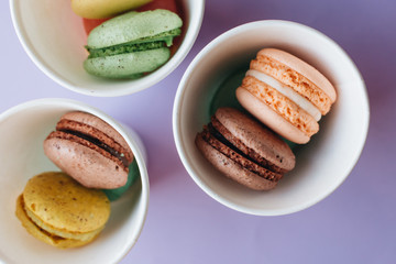 Composition of delicious macaroons on purple background