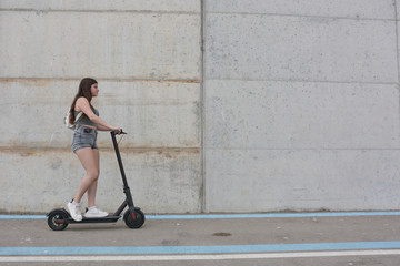 Teenage girl circulating with an electric scooter