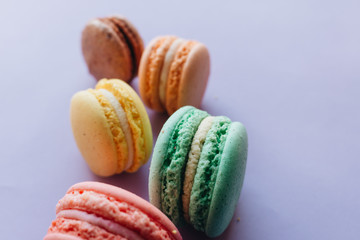 Composition of delicious macaroons on purple background
