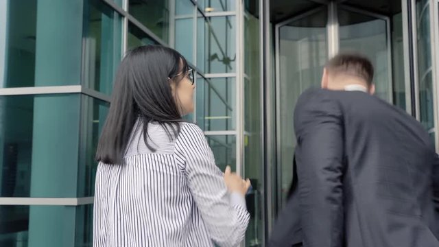 Business man leaving the office touching colleague woman. She slapping him by the face. Sexual harassment.