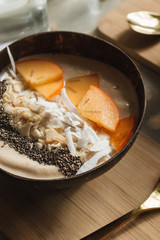 Bowl with sliced persimmon, nuts and chia seeds 