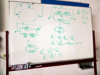 White board with schematic drawing and formulas of an electric circuit. Physics class.