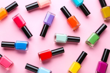 Fototapeta premium Nail polish bottles on pink background