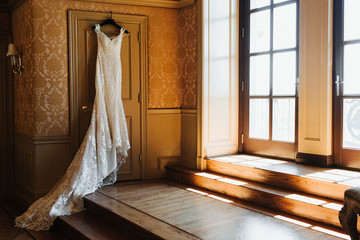 Wedding Gown Hanging in Room with Window Light