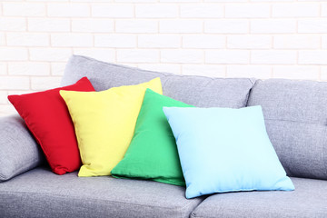 Colorful soft pillows on grey sofa