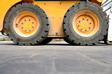 Heavy duty construction machinery, rubber tyres and orange metal body.