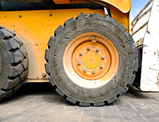A fore wheel and a heavy duty tyre, construction site machinery.