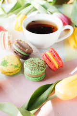 Cup of tea, delicious macaroon and bright tulips, sweet dessert