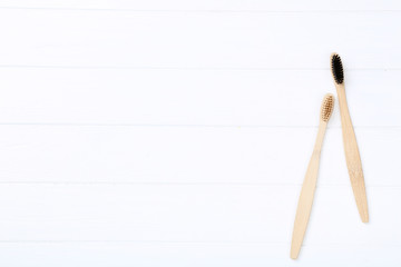 Bamboo toothbrushes on white wooden table