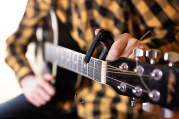 Instal a capodaster, also called capo, for guitar, put across the strings