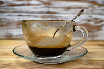 empty cup of espresso and a silver coffee spoon on a wooden table
