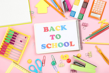 Text Back To School with stationery on pink background