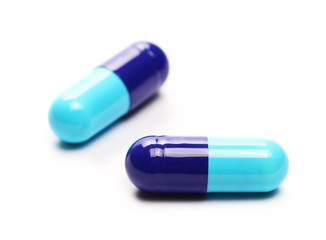 Blue pills macro, medicine isolated on white background
