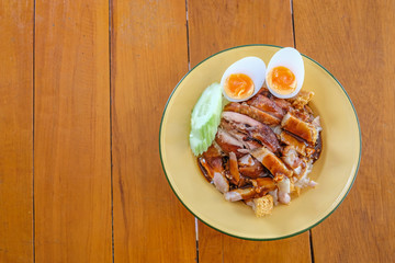 crispy pork rice with boiled egg in a light yellow dish