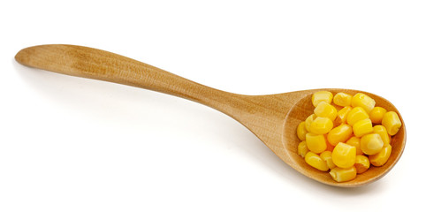 Corn seeds in a wooden spoon isolated on white background